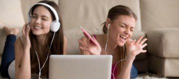 Jovenes mujeres con auriculares frente a una laptop