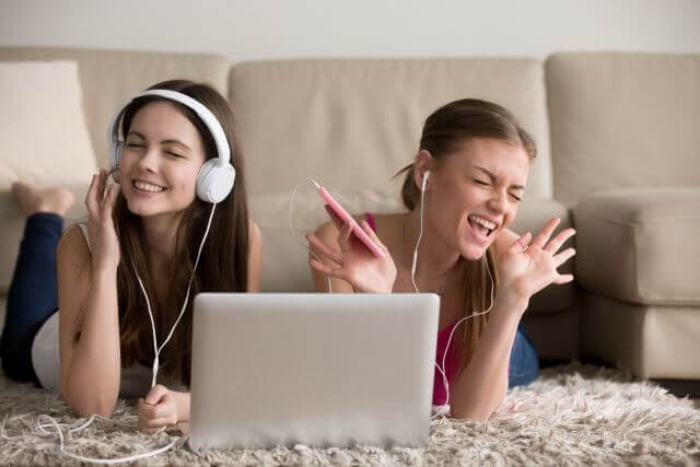 Jovenes mujeres con auriculares frente a una laptop