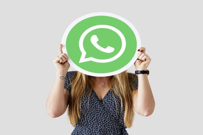 Mujer mostrando un ícono de WhatsApp