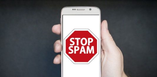 Hombre sostiene un móvil en su mano con un mensaje de stop spam
