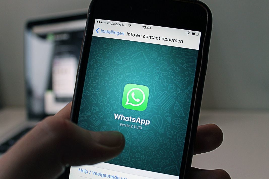 Hombre tiene móvil en la mano con el logo de Whatsapp