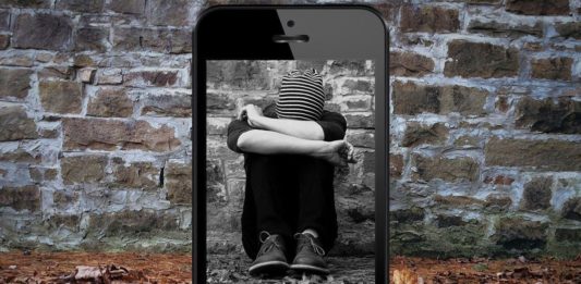 Imagen de un joven cubriendo su cara mostrada a través de un móvil