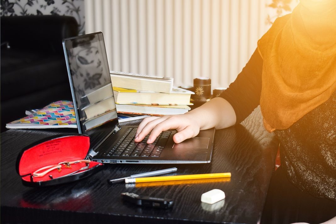 Mujer joven escribe en un ordenador