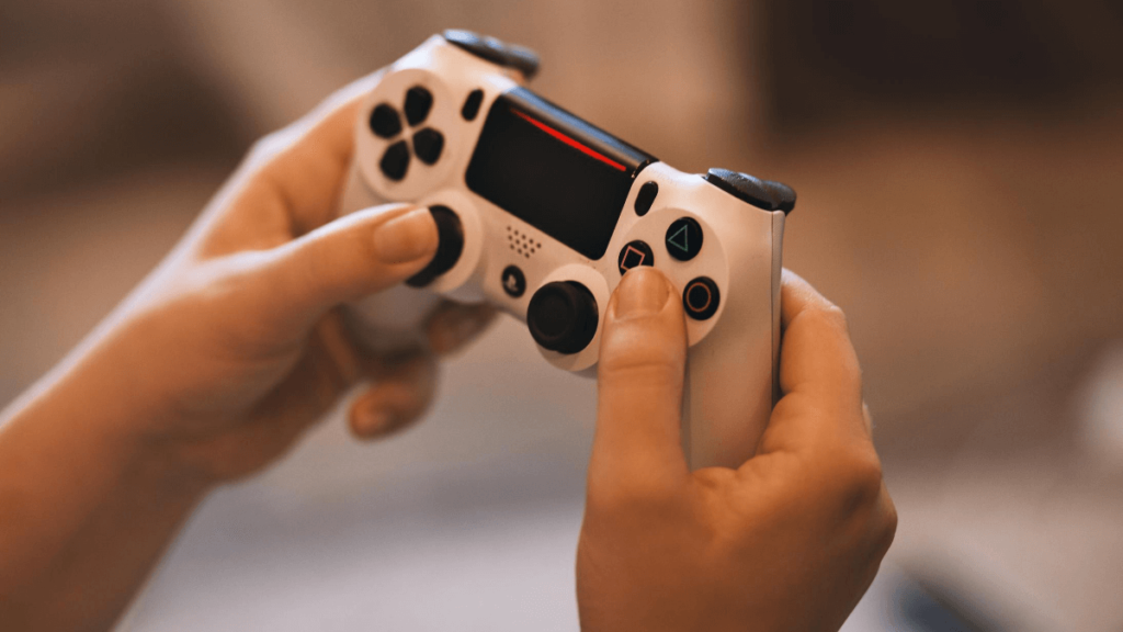 manos de un joven sostienen un control de videojuegos