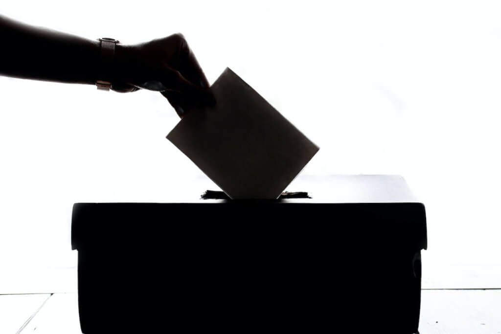 Echando voto en urna