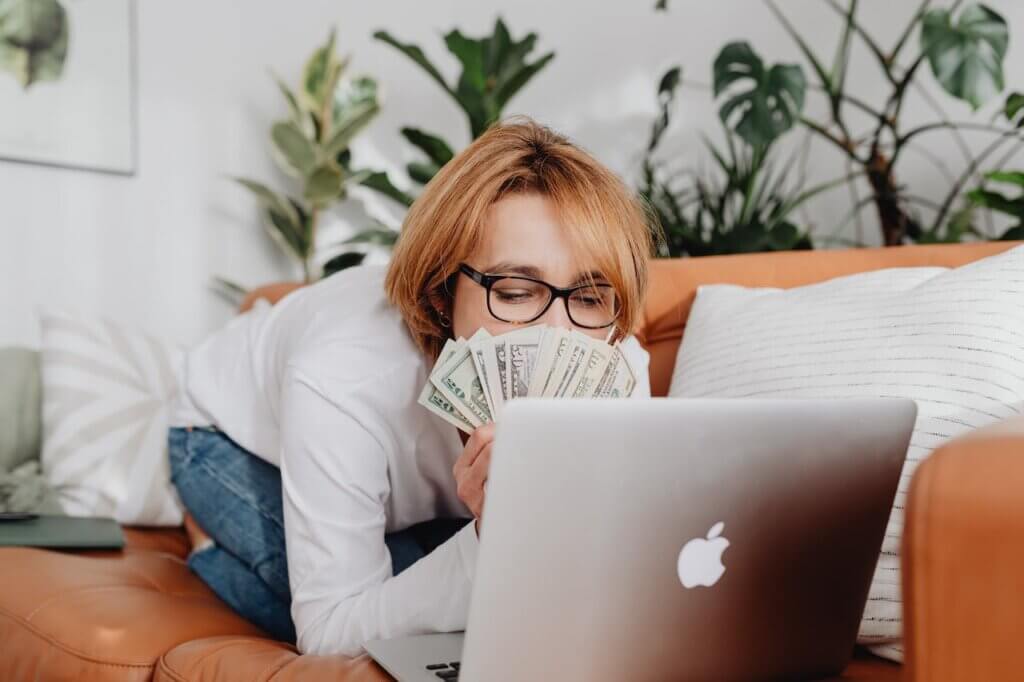 Mujer con dinero frente a ordenador